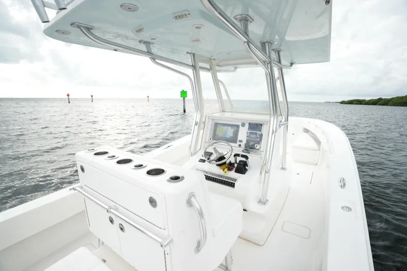 Slide: The Image of 2012 Invincible 33 Open Fisherman boat on calm waters, featuring a sleek console and spacious deck. - 31