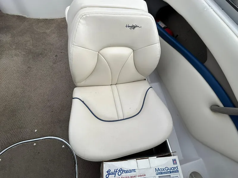 Slide: The Image of White seat in a 2001 Four Winns 180 Horizon boat, with carpeted floor and box nearby. - 13