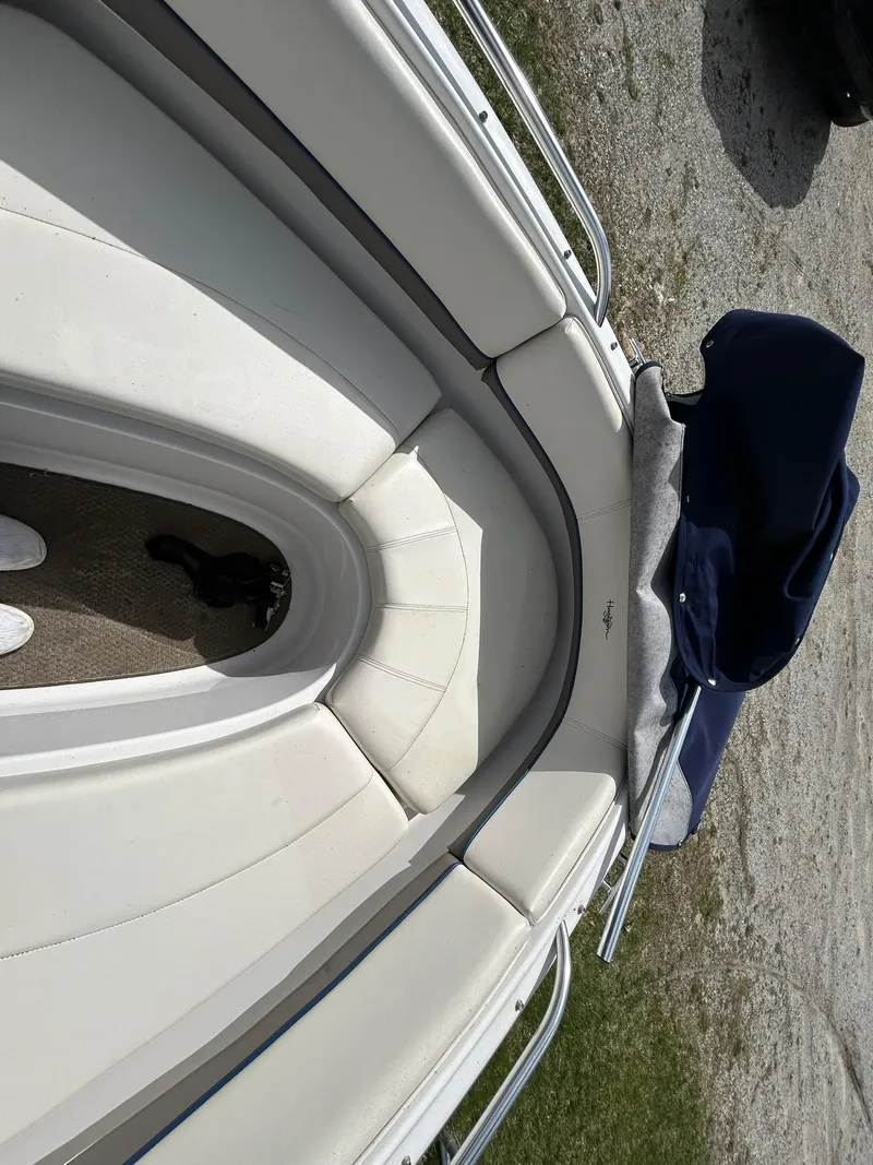 Slide: The Image of 2001 Four Winns 180 Horizon boat interior with white seating and blue cover. - 17