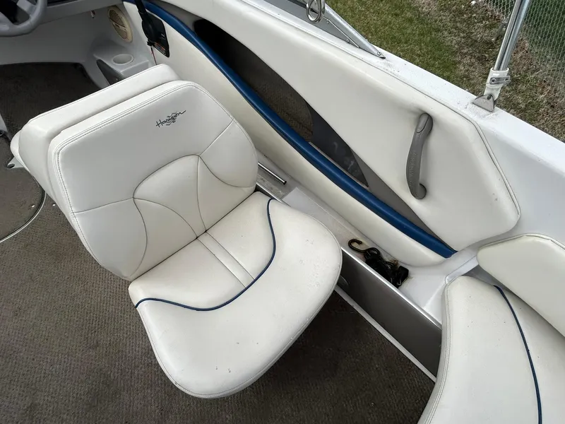Slide: The Image of 2001 Four Winns 180 Horizon boat interior with white seating and blue accents. - 5