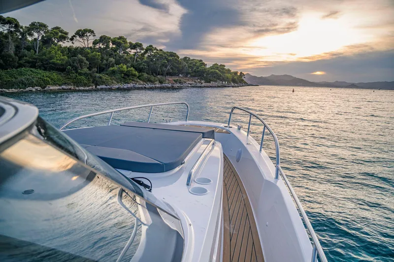 Slide: The Image of Nimbus Tender 11 boat cruising at sunset near a scenic coastline, 2025 model. - 13