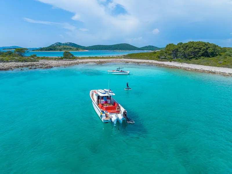 Slide: The Image of Nimbus Tender 11 boat in turquoise waters near a scenic island, 2025 model. - 20