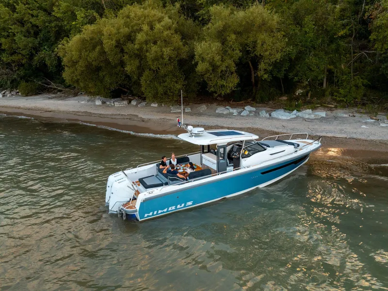Slide: The Image of Nimbus Tender 11 boat, 2025 model, anchored near a scenic shoreline. - 25