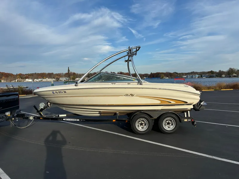 The Image of 1999 Sea Ray 190 Bow Rider boat on trailer by waterfront. - 0