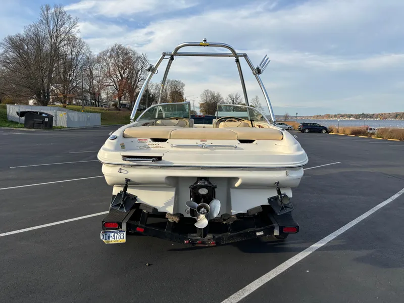Slide: The Image of 1999 Sea Ray 190 Bow Rider boat parked in a lot near a lake. - 10