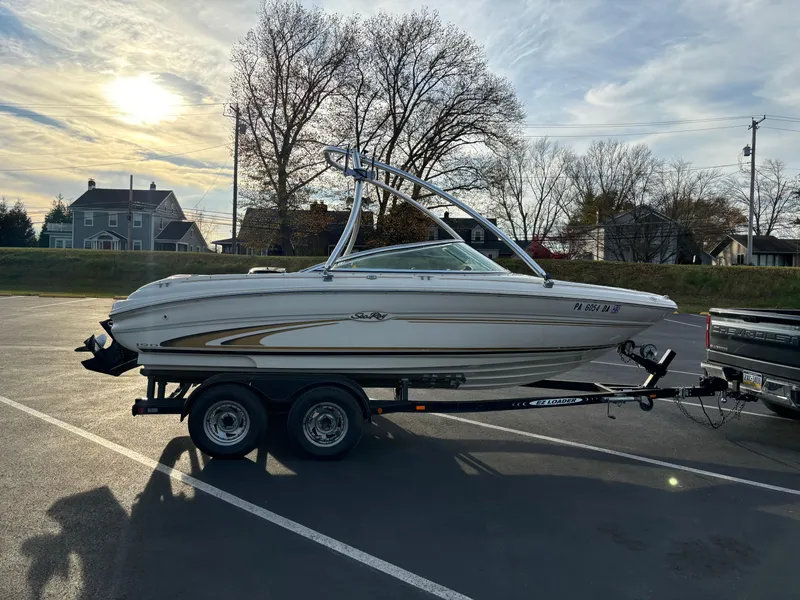 Slide: The Image of 1999 Sea Ray 190 Bow Rider on trailer in parking lot, under a clear sky. - 11