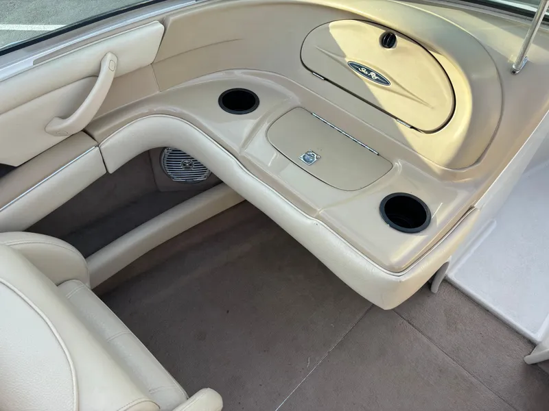 Slide: The Image of 1999 Sea Ray 190 Bow Rider interior with beige seating and cup holders. - 5