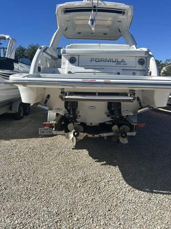 Slide: The Image of 2023 Formula 350 Crossover Bowrider boat, rear view, parked on gravel. - 3