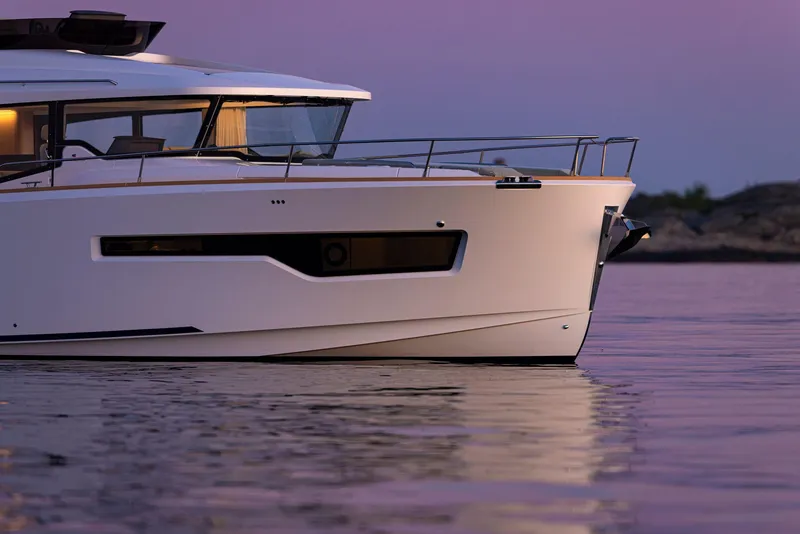 Slide: The Image of Nimbus 495 Flybridge 2025 yacht on calm water at sunset. - 2