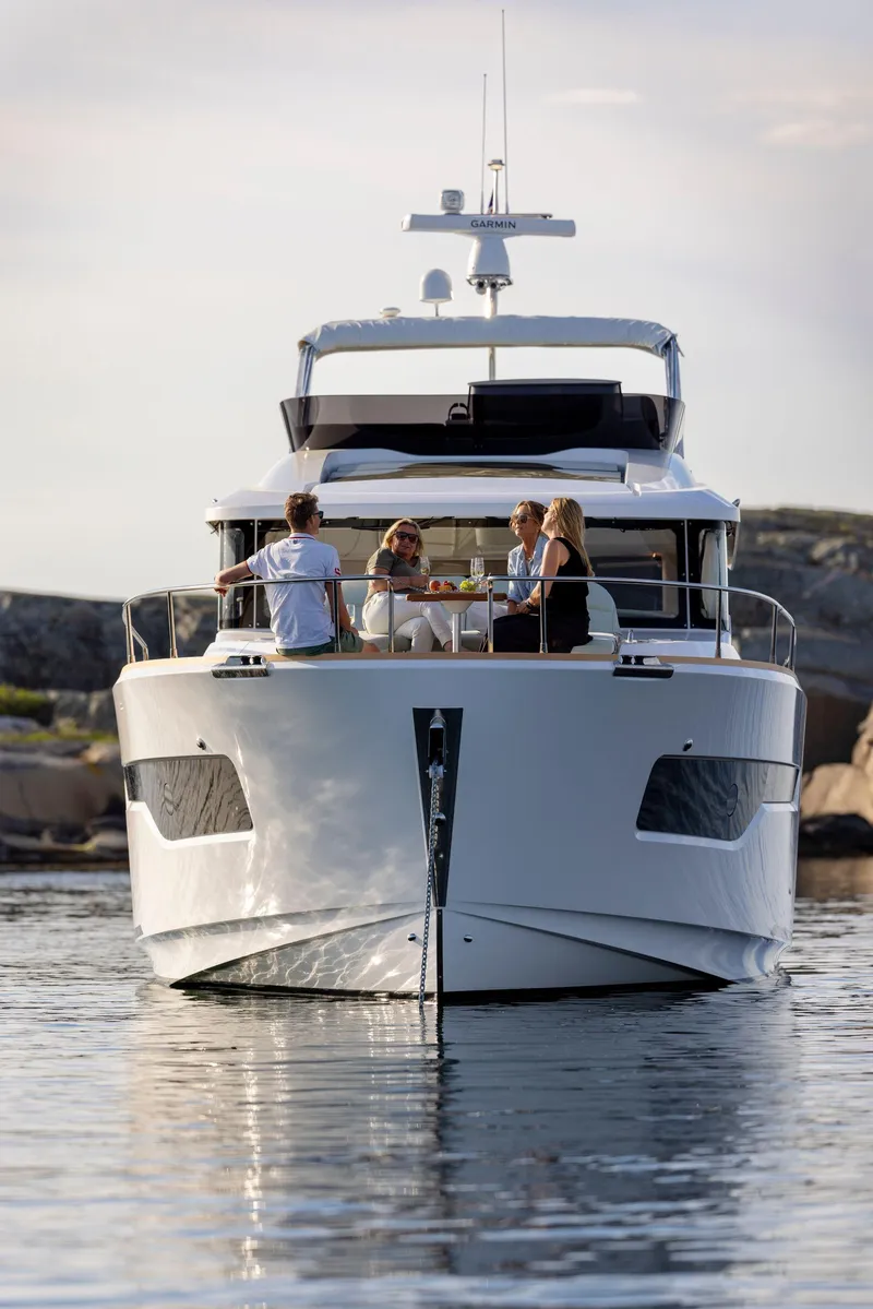 Slide: The Image of 2025 Nimbus 495 Flybridge yacht on calm water with people enjoying the deck. - 35