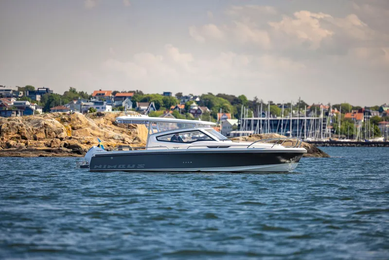 Slide: The Image of Nimbus Weekender 9 boat cruising near rocky shoreline, 2025 model. - 23