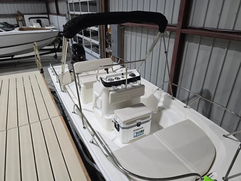 Slide: The Image of 2025 Boston Whaler 150 Montauk boat on trailer in storage facility. - 0