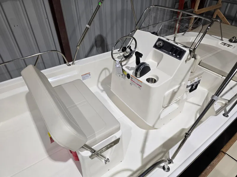 Slide: The Image of 2025 Boston Whaler 150 Montauk boat interior with steering console and seating. - 14