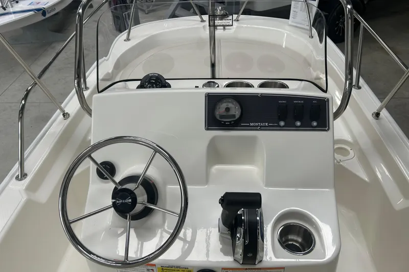 Slide: The Image of 2025 Boston Whaler 150 Montauk boat console with steering wheel and controls. - 15
