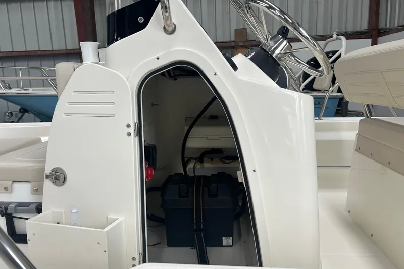 Slide: The Image of 2025 Boston Whaler 150 Montauk boat console with open storage compartment. - 17