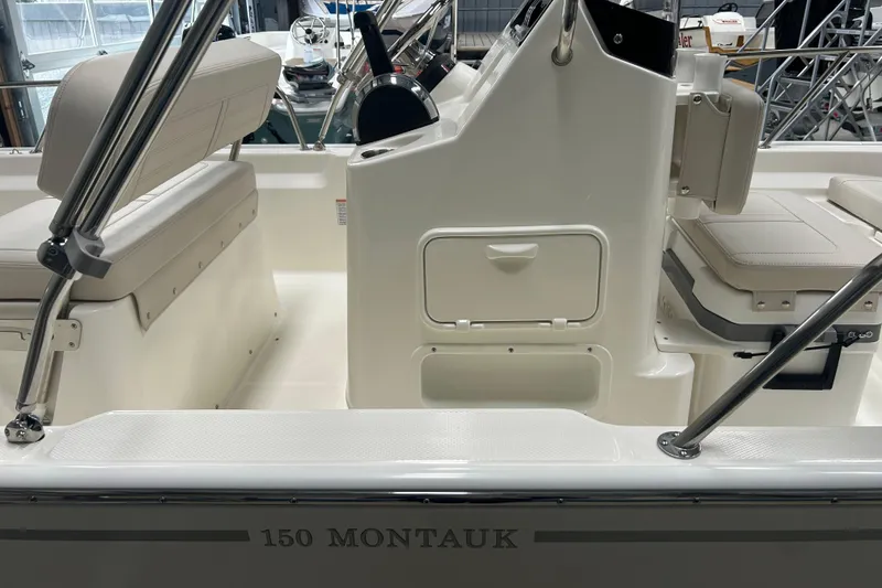 Slide: The Image of 2025 Boston Whaler 150 Montauk interior with seating and console details. - 18