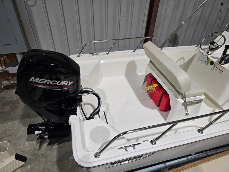 Slide: The Image of 2025 Boston Whaler 150 Montauk boat on trailer in indoor showroom. - 3