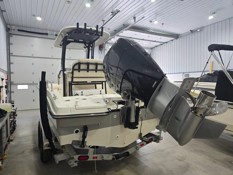 Slide: The Image of 2025 Boston Whaler 250 Dauntless boat interior with seating and console in a showroom. - 14