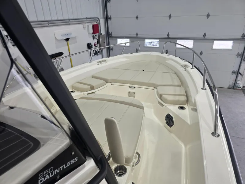 Slide: The Image of 2025 Boston Whaler 250 Dauntless boat interior with cushioned seating and engine view. - 20