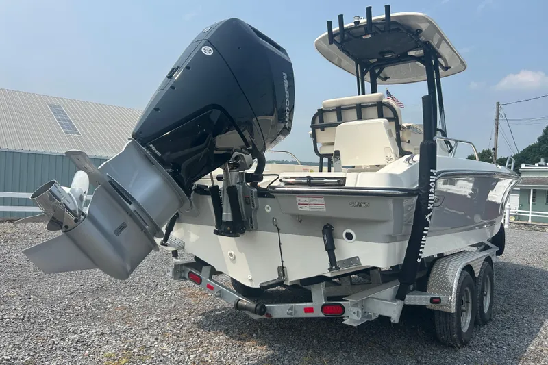 Slide: The Image of 2025 Boston Whaler 250 Dauntless boat in a garage, featuring a powerful outboard motor. - 6