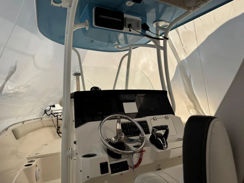 Slide: The Image of 2022 Sailfish 242 CC boat interior with steering wheel and control panel. - 4