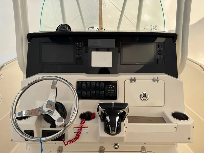 Slide: The Image of 2022 Sailfish 242 CC boat dashboard with steering wheel and navigation controls. - 5