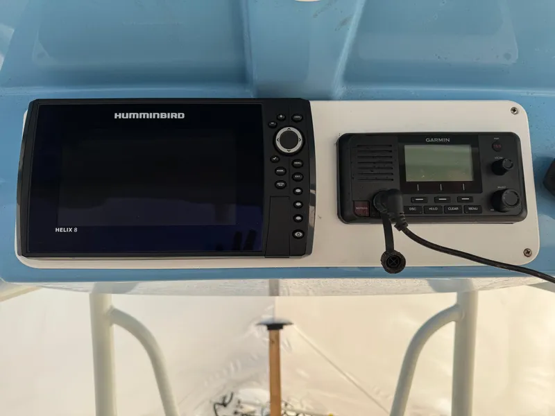 Slide: The Image of 2022 Sailfish 242 CC dashboard with Humminbird Helix 9 and Garmin marine radio. - 7
