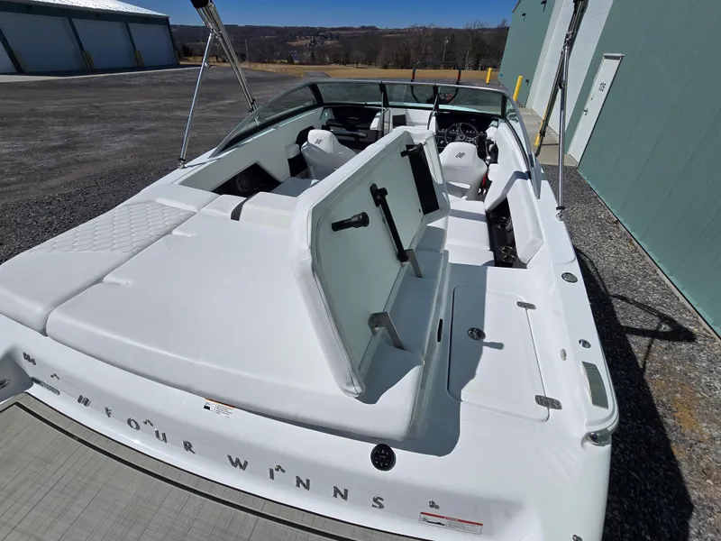 Slide: The Image of 2025 Four Winns H4 boat with open seating and sleek design, parked outdoors. - 11
