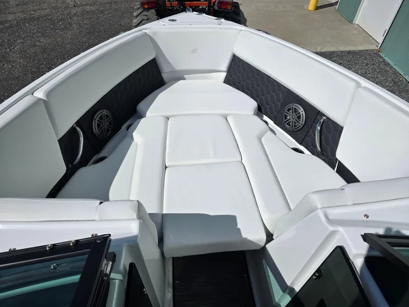 Slide: The Image of 2025 Four Winns H4 boat interior with white cushioned seating and speaker system. - 27