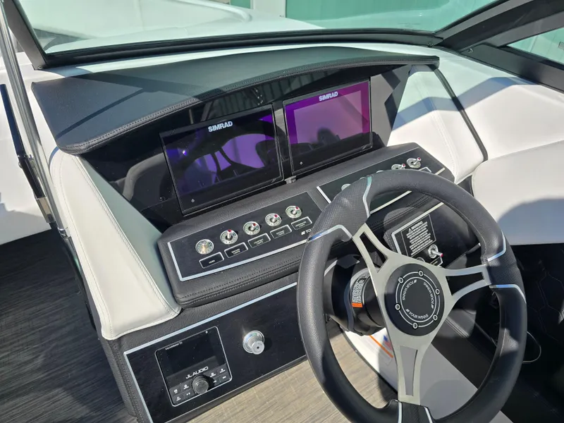 Slide: The Image of 2025 Four Winns H4 boat dashboard with dual Simrad displays and modern steering wheel. - 28