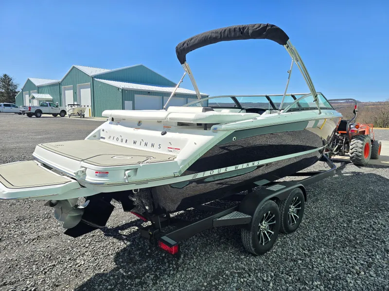 Slide: The Image of 2025 Four Winns H4 boat on trailer, parked outdoors under clear blue sky. - 7