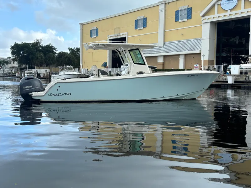 Slide: The Image of 2023 Sailfish 272 CC boat docked near a waterfront building. - 0