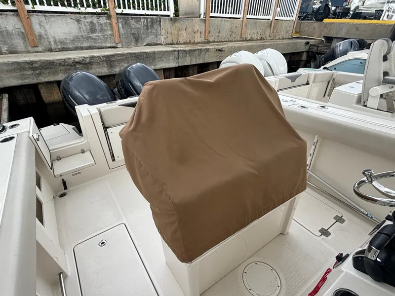 Slide: The Image of 2023 Sailfish 272 CC boat interior with covered seating and dual engines. - 11