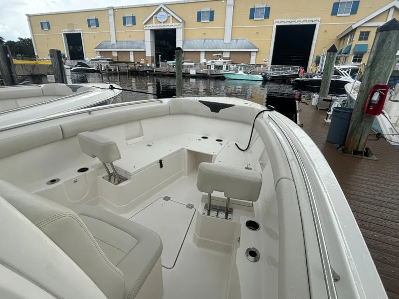 Slide: The Image of 2023 Sailfish 272 CC boat docked at marina with spacious seating area. - 18