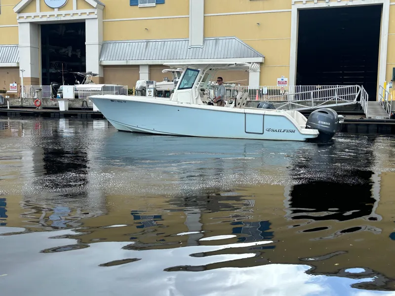 Slide: The Image of 2023 Sailfish 272 CC boat docked near a waterfront building. - 3