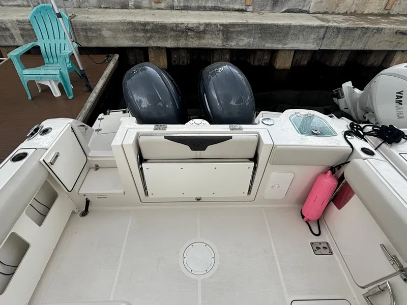 Slide: The Image of 2023 Sailfish 272 CC boat deck with dual engines and dockside view. - 9