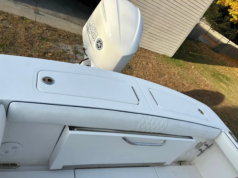 Slide: The Image of 2016 Regulator 23 Forward Seating boat with Yamaha outboard motor, parked on grass. - 4