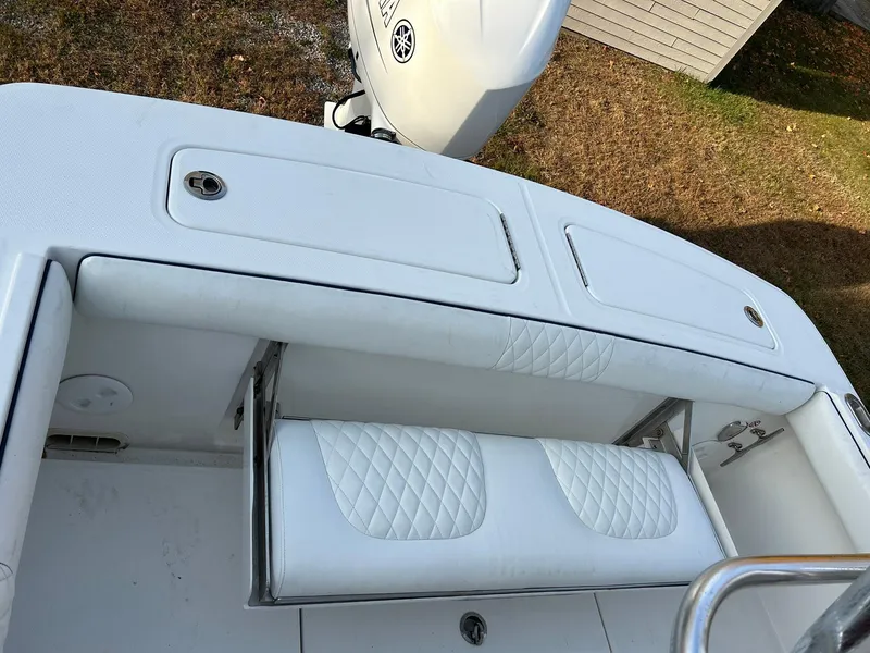 Slide: The Image of 2016 Regulator 23 Forward Seating boat with white cushioned seats and storage compartments. - 5