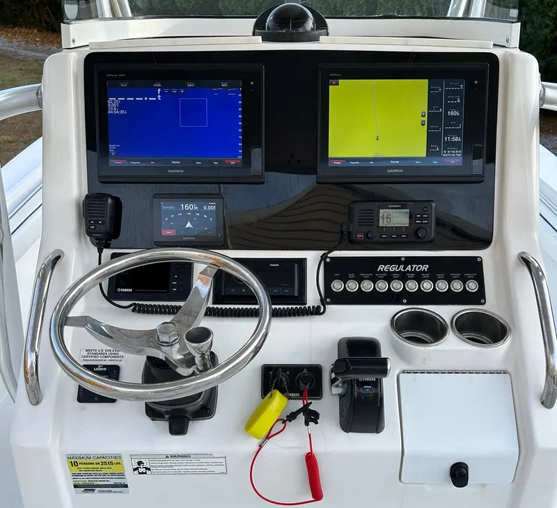 Slide: The Image of 2016 Regulator 23 Forward Seating boat dashboard with navigation screens and controls. - 8