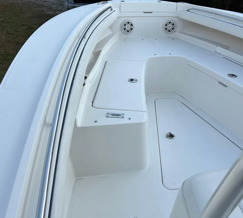 Slide: The Image of 2016 Regulator 23 Forward Seating boat interior with white seating and storage compartments. - 9