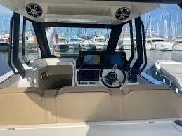 Slide: The Image of 2025 Zodiac X10CC boat interior with modern dashboard and steering, docked at marina. - 14
