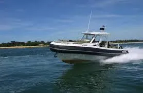 Slide: The Image of 2025 Zodiac X10CC boat speeding on open water under clear blue sky. - 2
