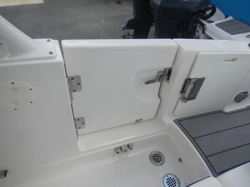 Slide: The Image of 2022 Chaparral 280 OSX boat interior, featuring a white access door and deck details. - 4