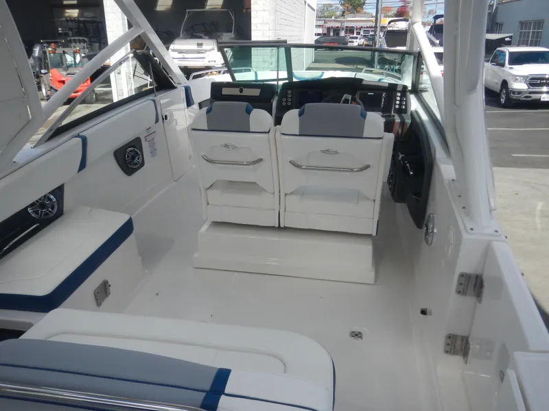 Slide: The Image of 2022 Chaparral 280 OSX boat interior with white seating and modern dashboard. - 9