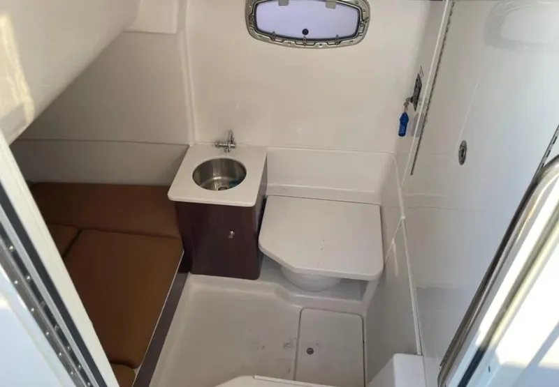 Slide: The Image of 2023 Robalo R360 Center Console cabin with sink and seating area. - 19