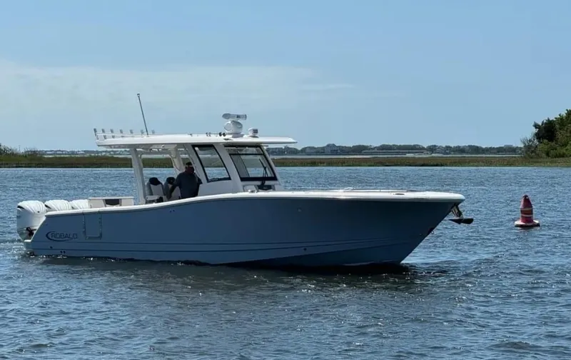 Slide: The Image of 2023 Robalo R360 Center Console boat cruising on a calm waterway. - 2