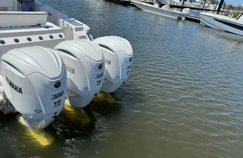 Slide: The Image of 2023 Robalo R360 Center Console with triple Yamaha 300 engines docked in marina. - 4
