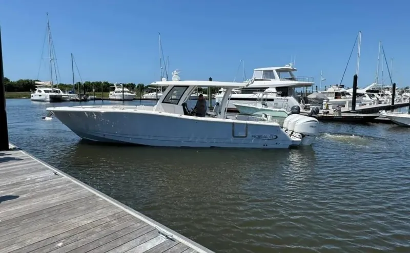 Slide: The Image of 2023 Robalo R360 Center Console boat docked in a marina. - 6