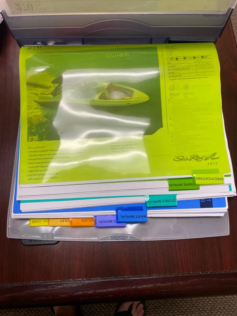 Slide: The Image of 2013 Sea Ray 270 SLX brochure on a table, featuring boat specifications and image. - 20