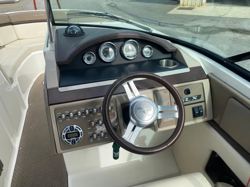 Slide: The Image of 2013 Sea Ray 270 SLX boat interior with beige seating and cup holders. - 7